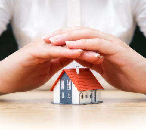 house covered of woman hands - insurance real estate concept
